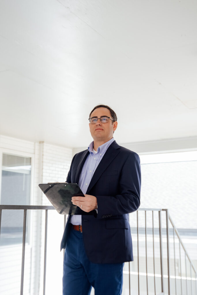 man with a clipboard inspecting a building