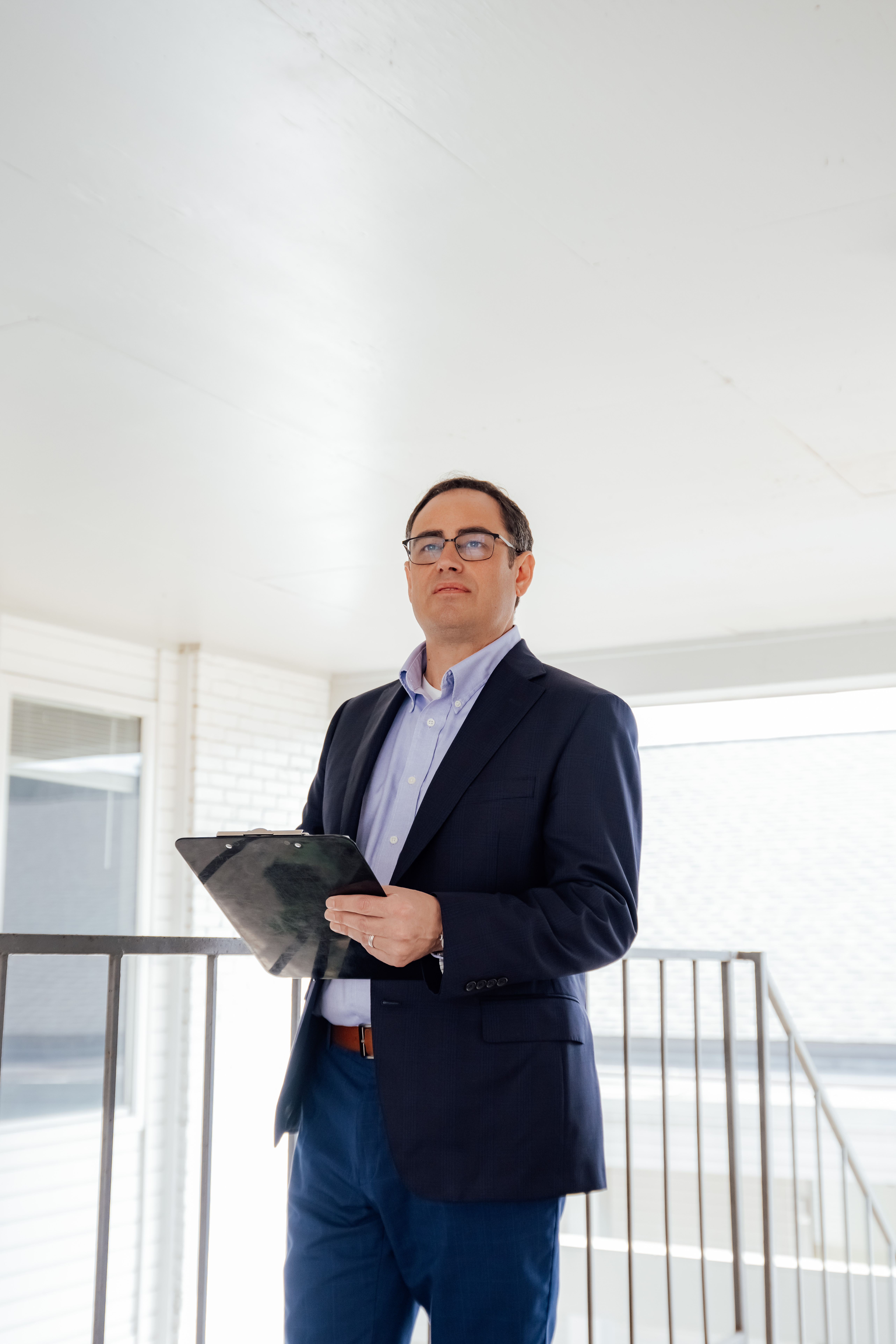 man with a clipboard inspecting a building